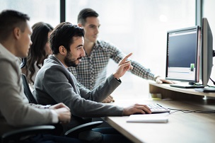 Employees working at a desktop computer