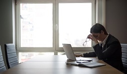 User looking sad while sitting at laptop after having lost work