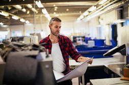 Man in print shop preparing to move